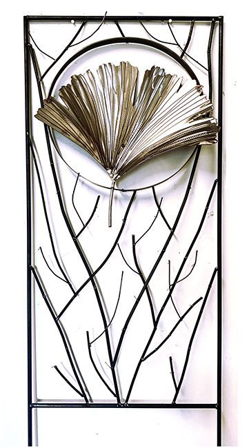 A metal ginkgo leaf sits near the top of this screen. Rather than flat sheet metal, this version is a trellis. Metal branches will be covered by climbing plants.