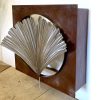 A metal box that was hand built to cover an air outlet. The colour is dark rust and was clear coated. The front has a large hole, with a stainless steel metal ginkgo leaf.